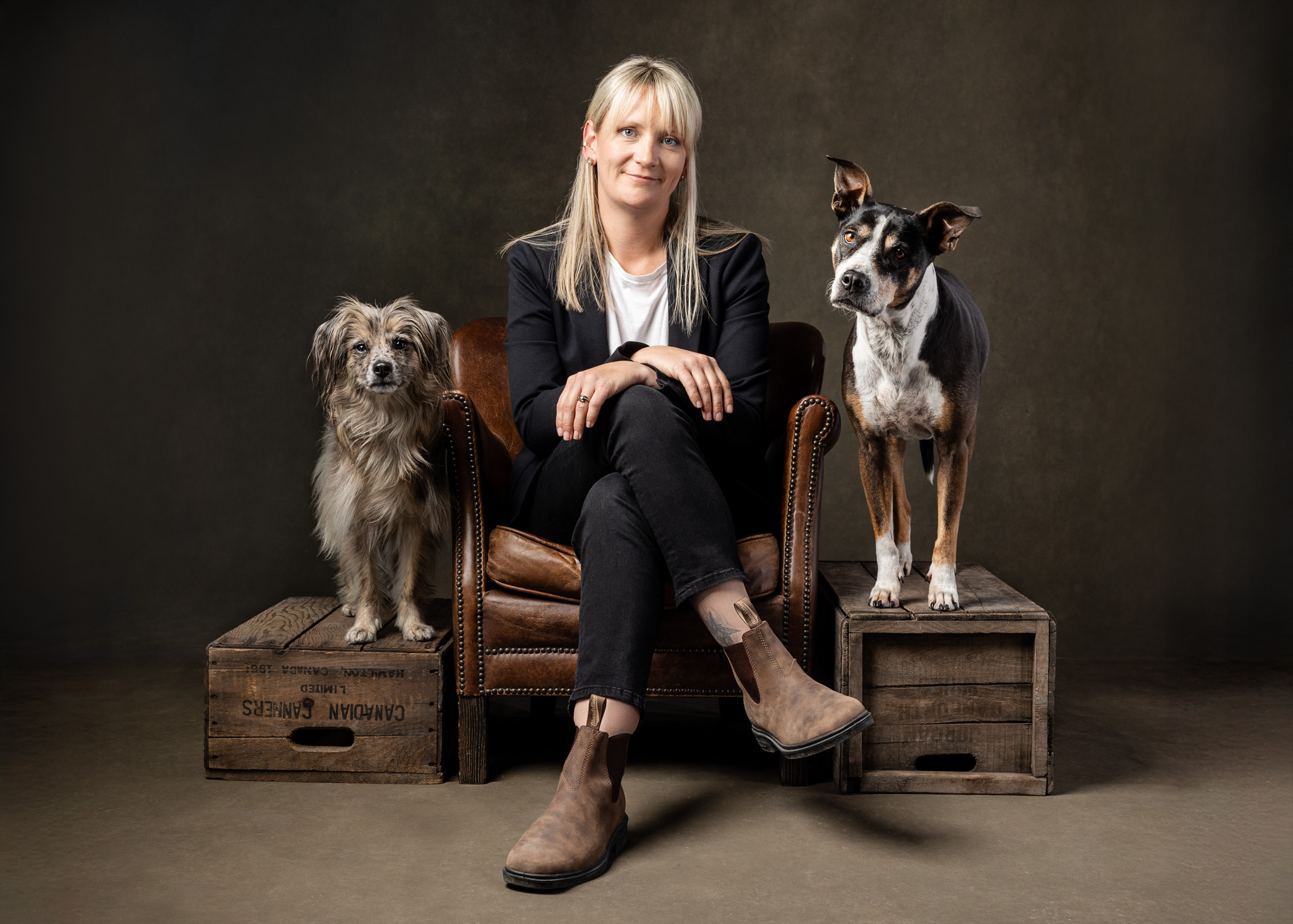 woman sitting in club chair with her two dogs on either side of her niagara studio dog photography