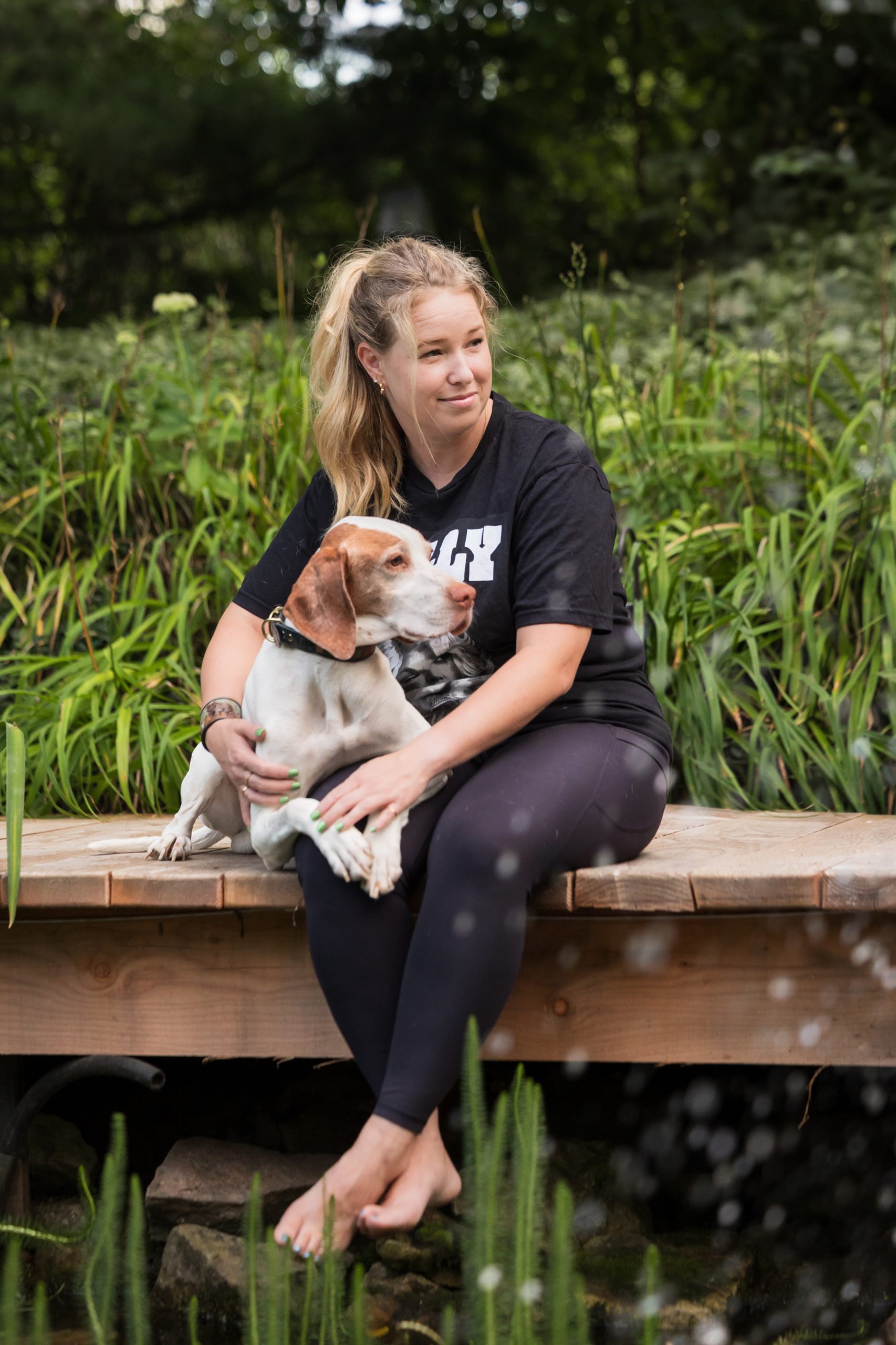 dog mom and her pointer sitting on the edge of a bridge looking off camera with Beamsville dog photographer