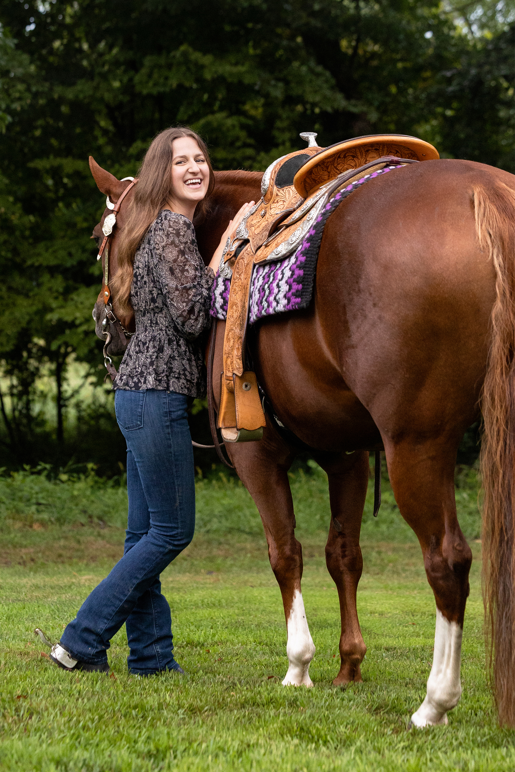 portrait of laughing woman with her horse in western tack