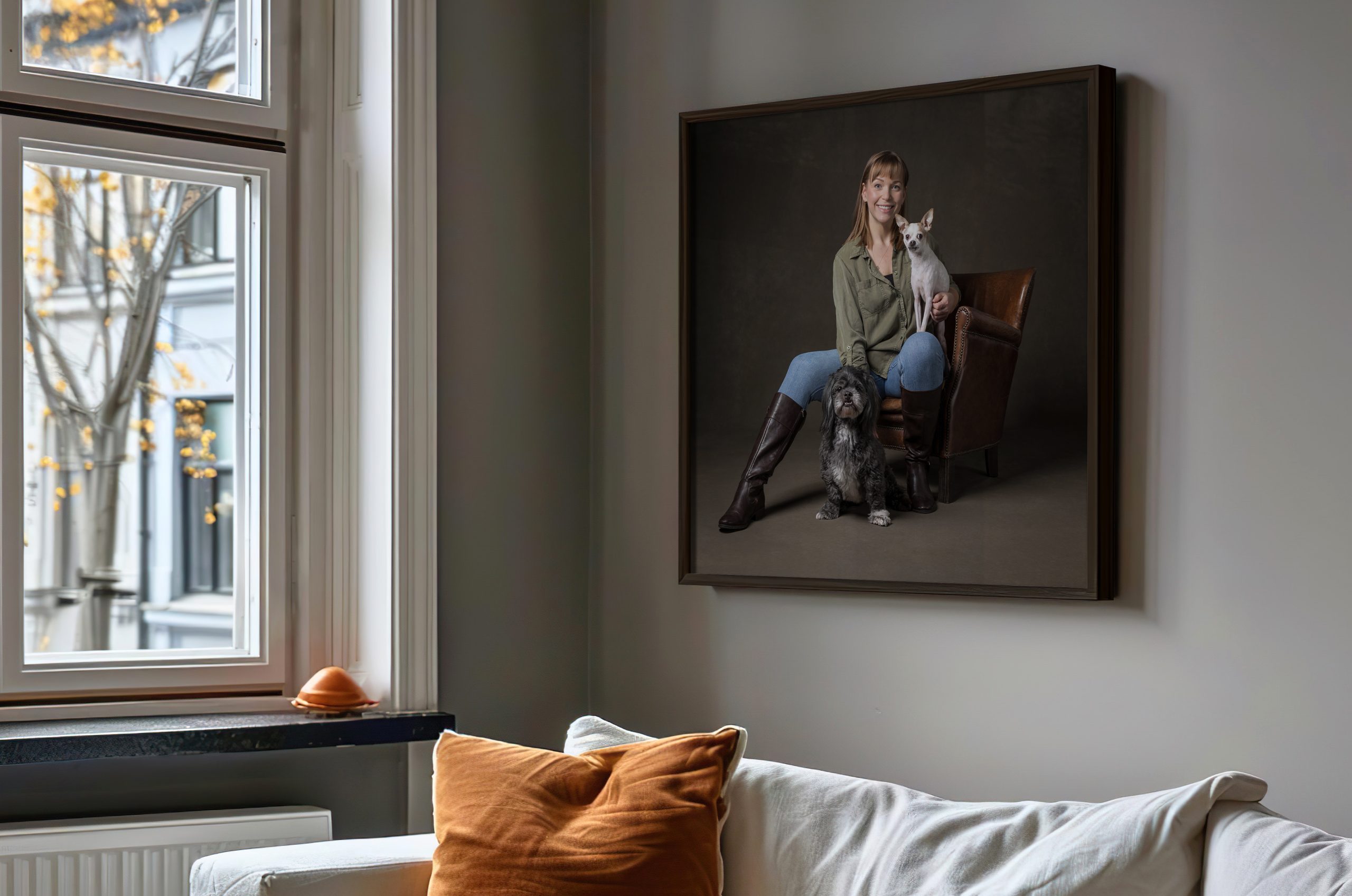 Framed fine art pet portrait of a woman and her two dogs displayed above a sofa, Indigo Pet Photography St. Catharines
